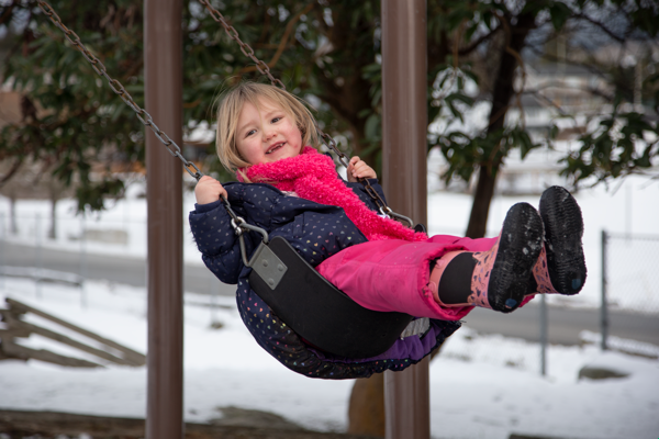 young girl playing on swing