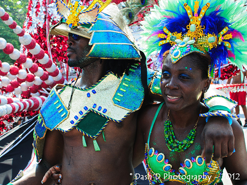 Image 3: Headshot of man and woman dressed in colourful carnival attire.