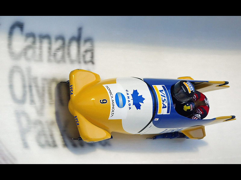 Image 9: Photo of Lesa Mayes Stringer in a bobsled, going down a bobsled run.