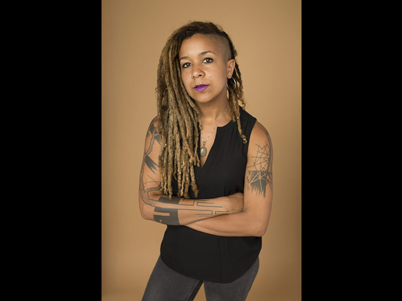 Image 11: Full body photo of Robyn Maynard with her arms crossed.